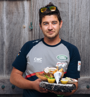 A chef holds his winning dish of lion fish