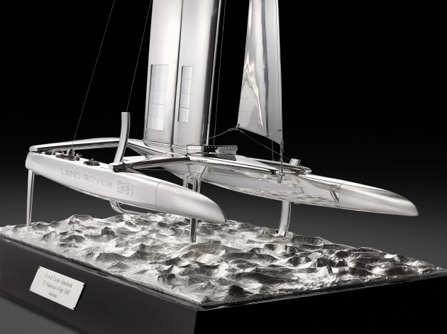 A silver sculpture of a foiling catamaran