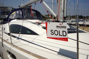 A white yacht with a sold sign on it