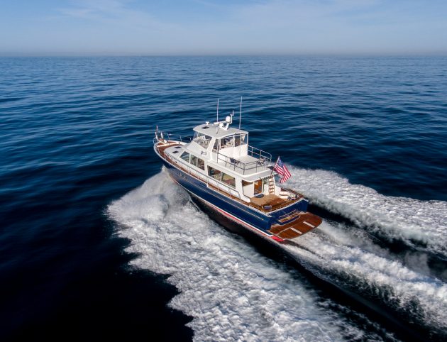 A motor yacht with an American flag on the back heading out to sea