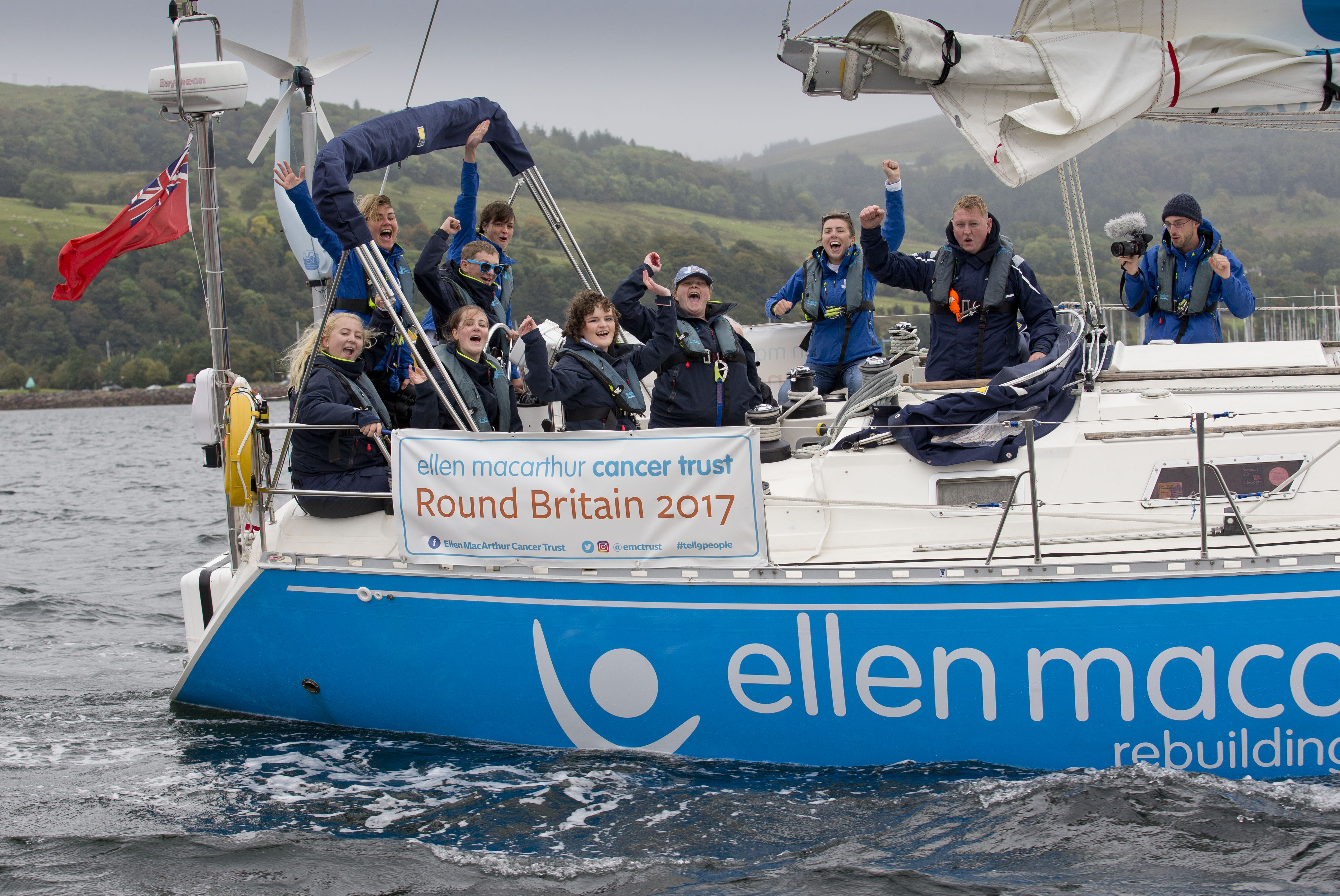 Young people on board a turquoise and white yacht