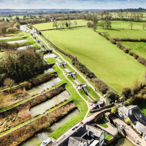 An aerial view of locks and green fields in England