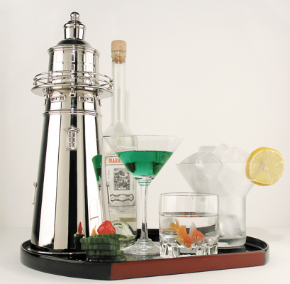 A silver cocktail shaker shaped like a lighthouse on a tray with drinks