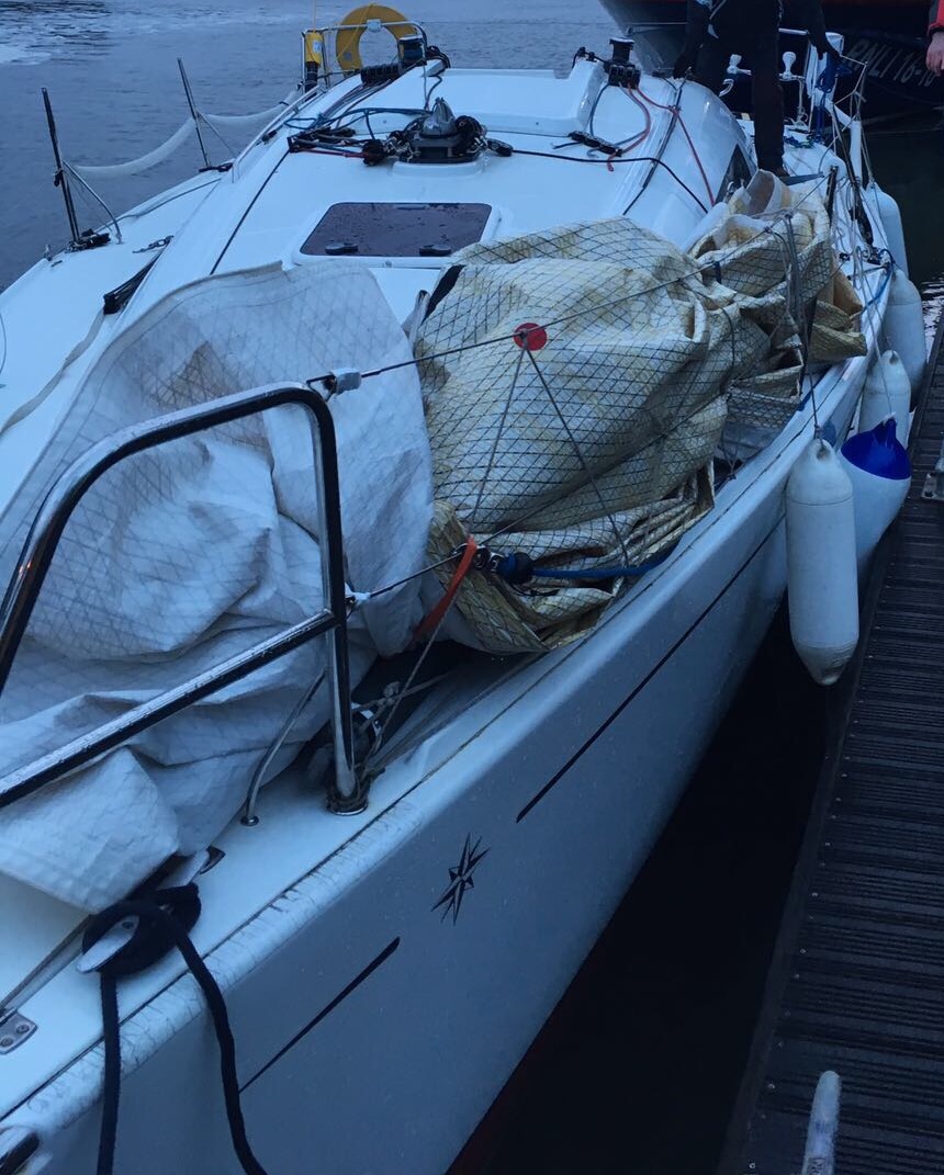 A white dismasted yacht moored alongside after rescue in the Bristol Channel