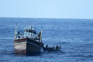 A fast RIB with crew comes alongside a fishing boat in the Indian Ocean