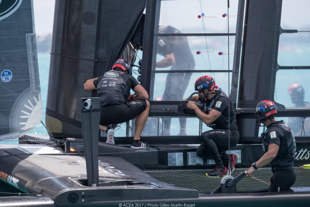 Sailors inspect damage to an America's Cup boat