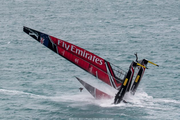 A red and black America's Cup catamaran capsizes