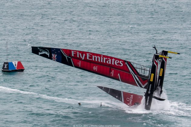 A red and black America's Cup catamaran pitchpoling