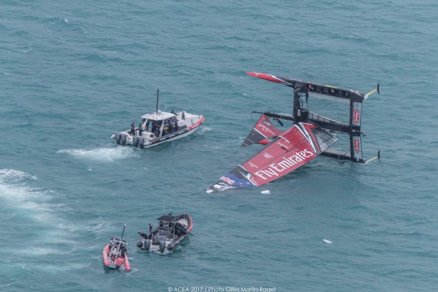 Two boats approach at capsized catamaran