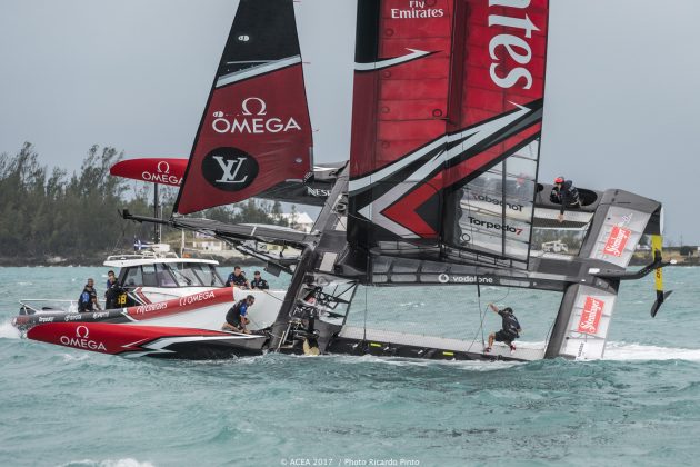 Sailors dressed in black on board a capsizing catamaran in the 35th America's Cup