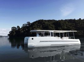 A white solar electric yacht, SoelCat 12, at anchor