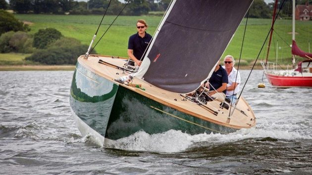 A Spirit yacht with a green hull and black and white sails