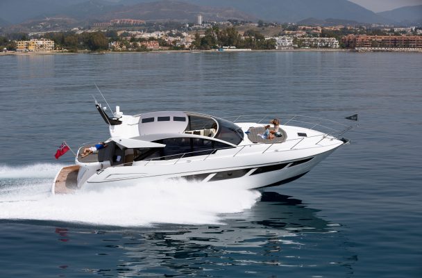 A white motor yacht speeding along the water