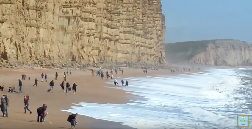 People playing on a Dorset beach ahead of a cliff fall