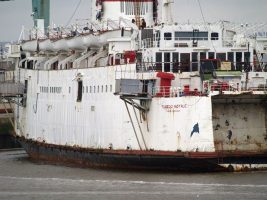 A derelict white ship moored up