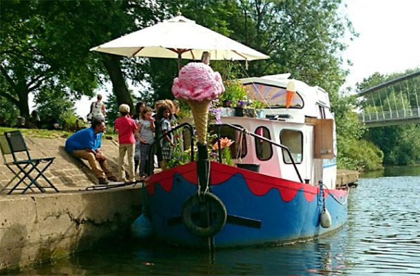 A red and blue tug with an ice cream van