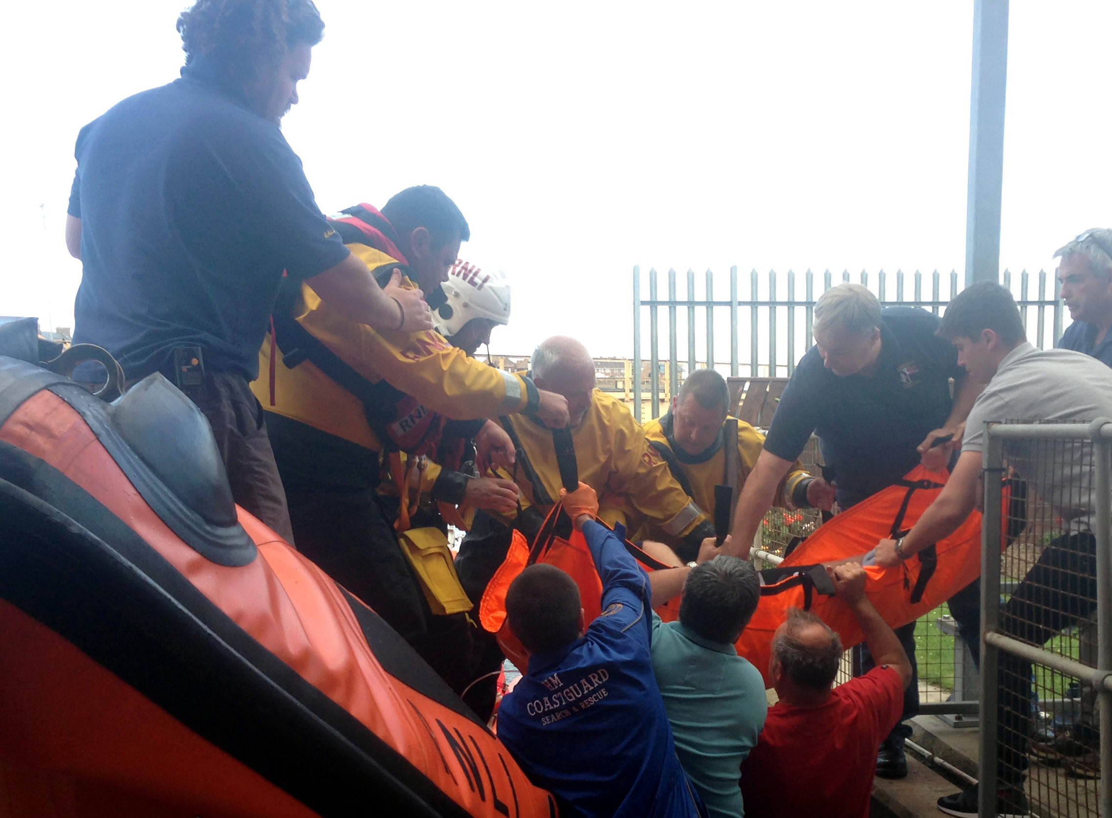 A person in an orange sling is transfered ashore after being rescue from Seaton Carew