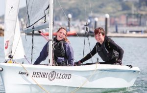 Two people in a white boat sponsored by Henri Lloyd to promote the 2017 Bart's Bash in September