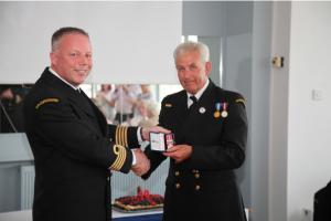 man receiving a medal from another man