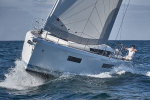 A Jenneau Sun Odyssey in white cruising through the water