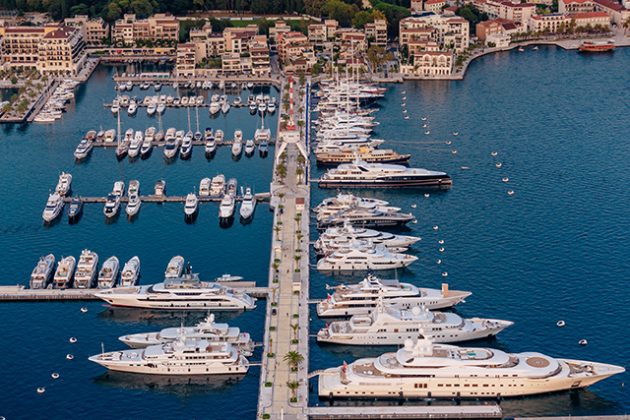 Superyacht and other yachts line up in a marina in Montenegro