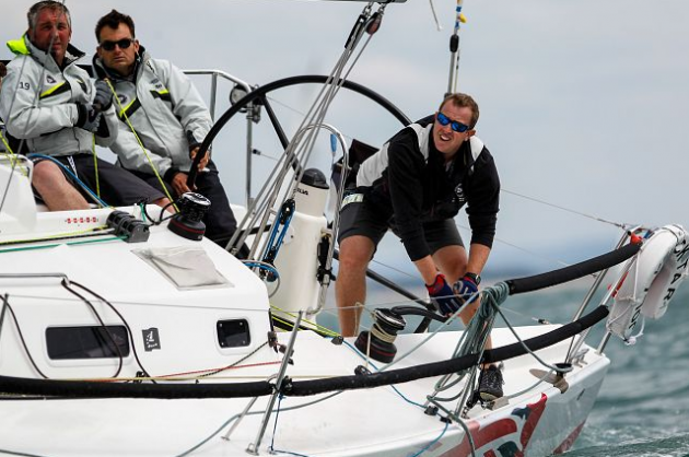 A man helming a racing yacht