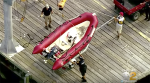 A red RIB is recovered from the water after was involved in an accident which killed a 12-year-old boy during a sailing lesson