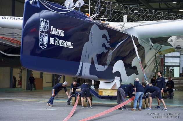 Men help to move the massive 100-foot maxi trimaran Maxi Edmond de Rothschild
