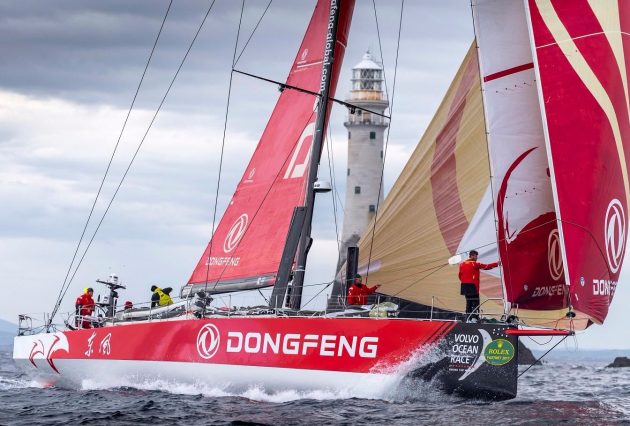 A red and white yacht round the iconic Fastnet Rock