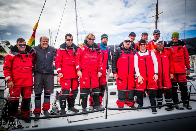 Dressed in red sailing gear, the crew of a Cookson 50 yacht in Plymouth