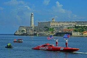 Two powerboat pilots stand on their red powerboat celebrating their Key West to Havana crossing