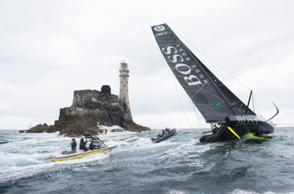 A black yacht rounds the Fastnet rock