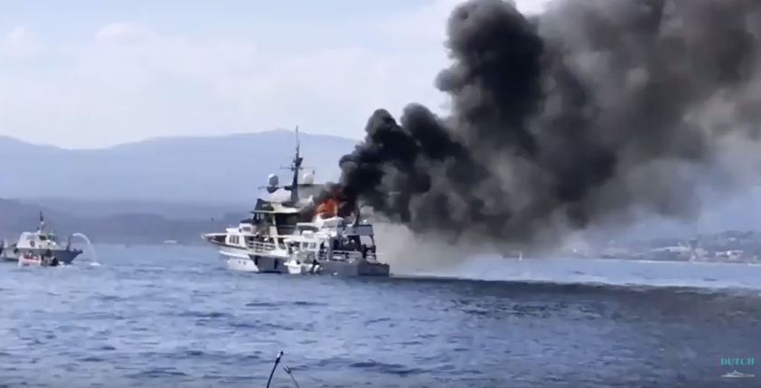 A white motor yacht with black smoke and flames off Nice