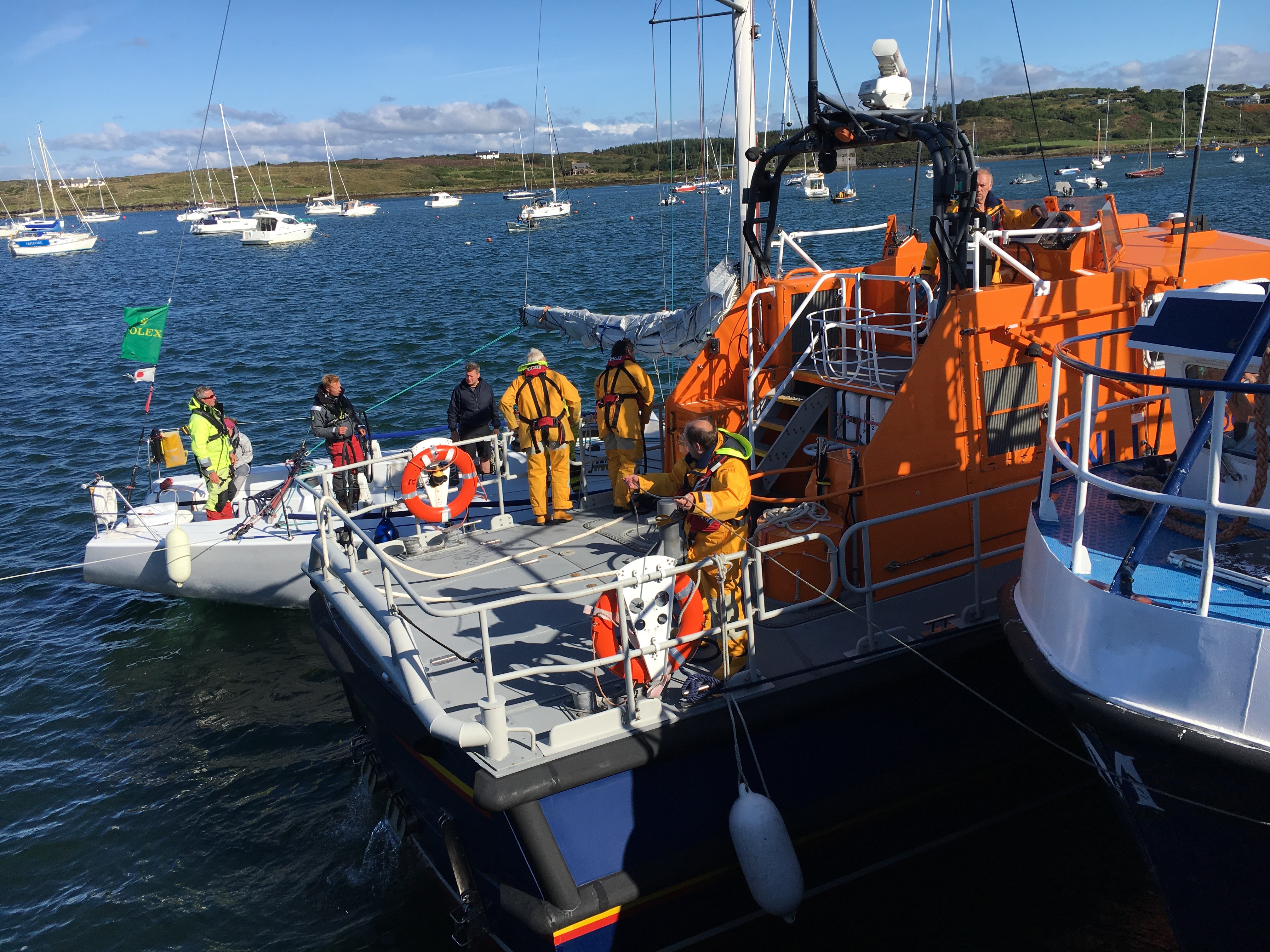 A yacht taking part in the Fastnet Race alongside a lifeboat which went to the aid of the crew when the yacht's rigging broke