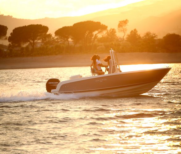 An open boat being driven at sunset