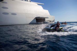 man on jetski driving by sailing yacht a