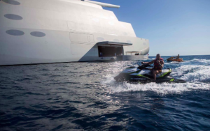 man on jetski driving by sailing yacht a