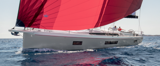 A white yacht with red sails