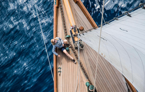 A man sitting on the deck of a yacht