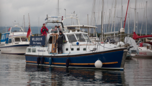 People in wet weather gear on board a motor cruiser at Scotland's Boat Show