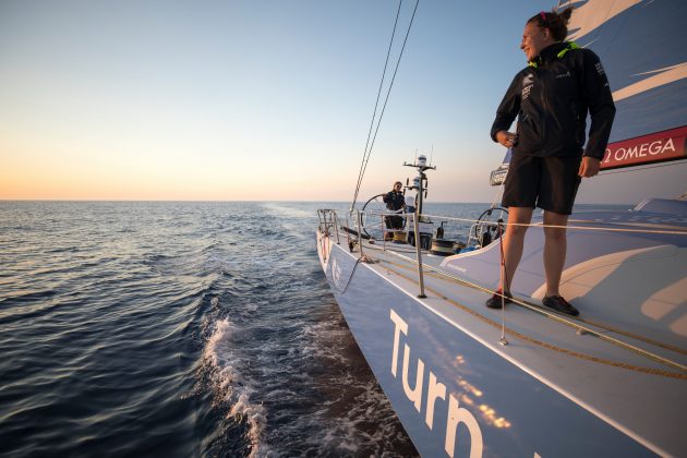 A sailor stands on a Volvo Ocean Race yacht