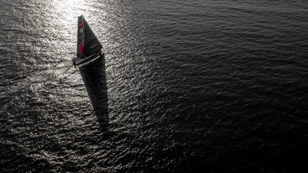 A yacht at full sail at dusk