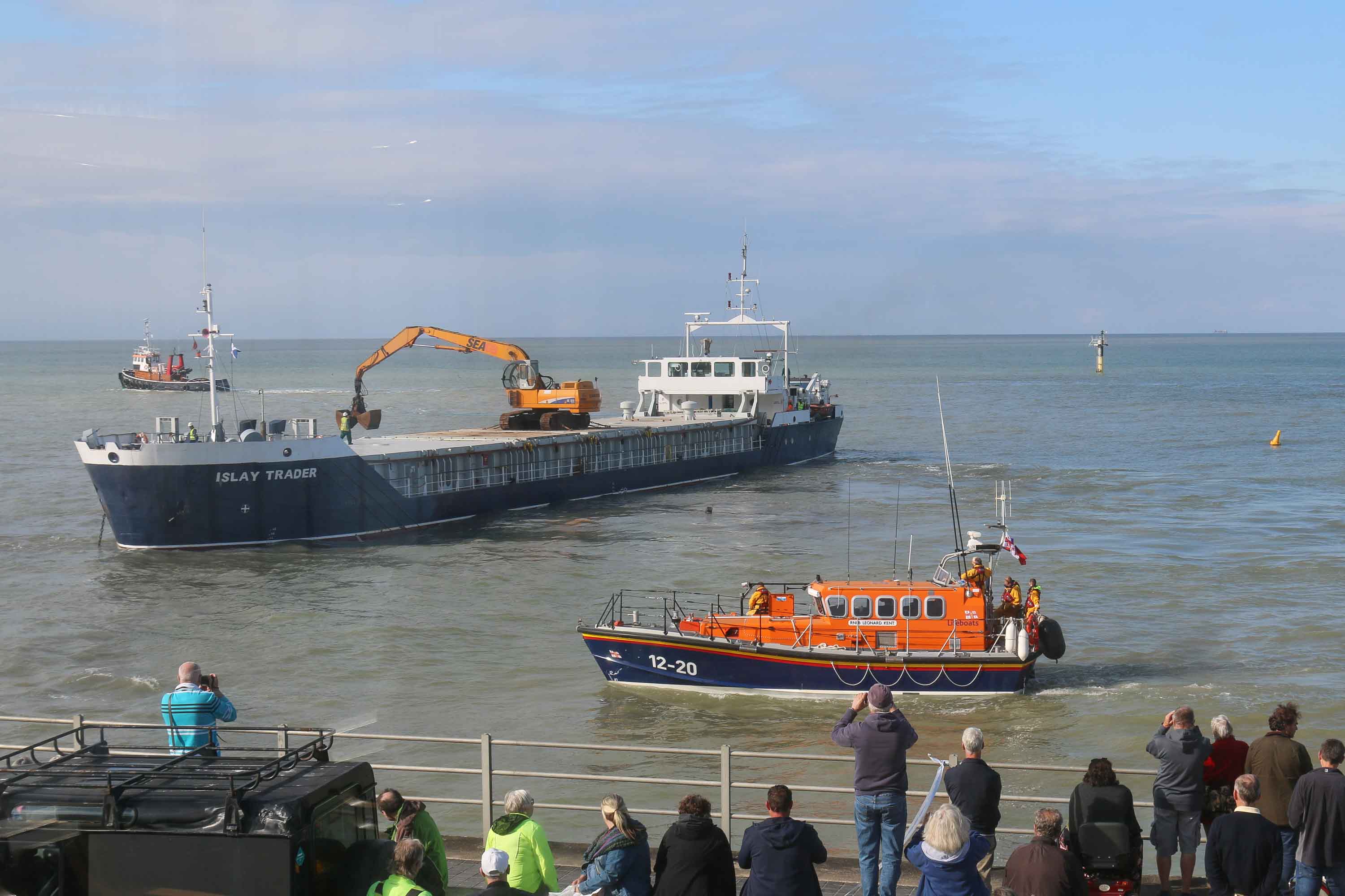 A cargo ship aground off Margate with an orange RNLI lifeboat providing safety cover