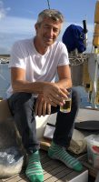 Golden Globe Race sailor Ertan Beskardes in a white tshirt and sipping a beer