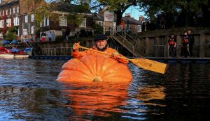 Tom Pearcy rowing a pumpkin boat down the River Ouse in York