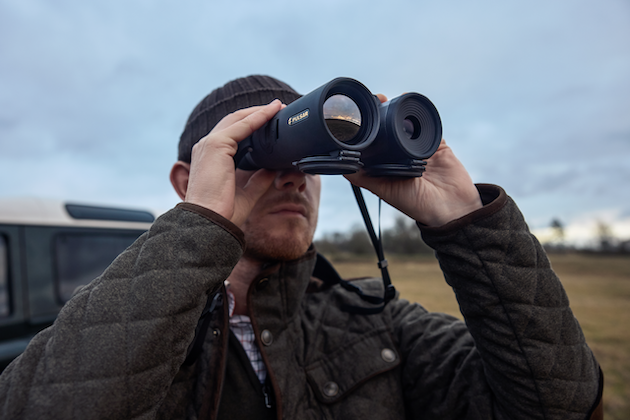 man looking through binoculars 