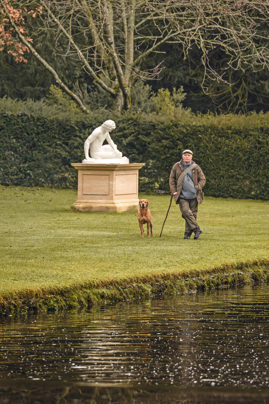 man by statue with dog