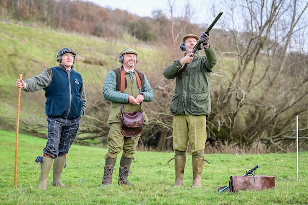 men in country with shotguns