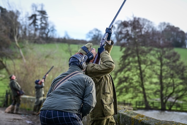 man shooting shotgun