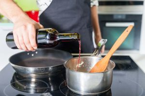 Pouring red wine into a saucepan